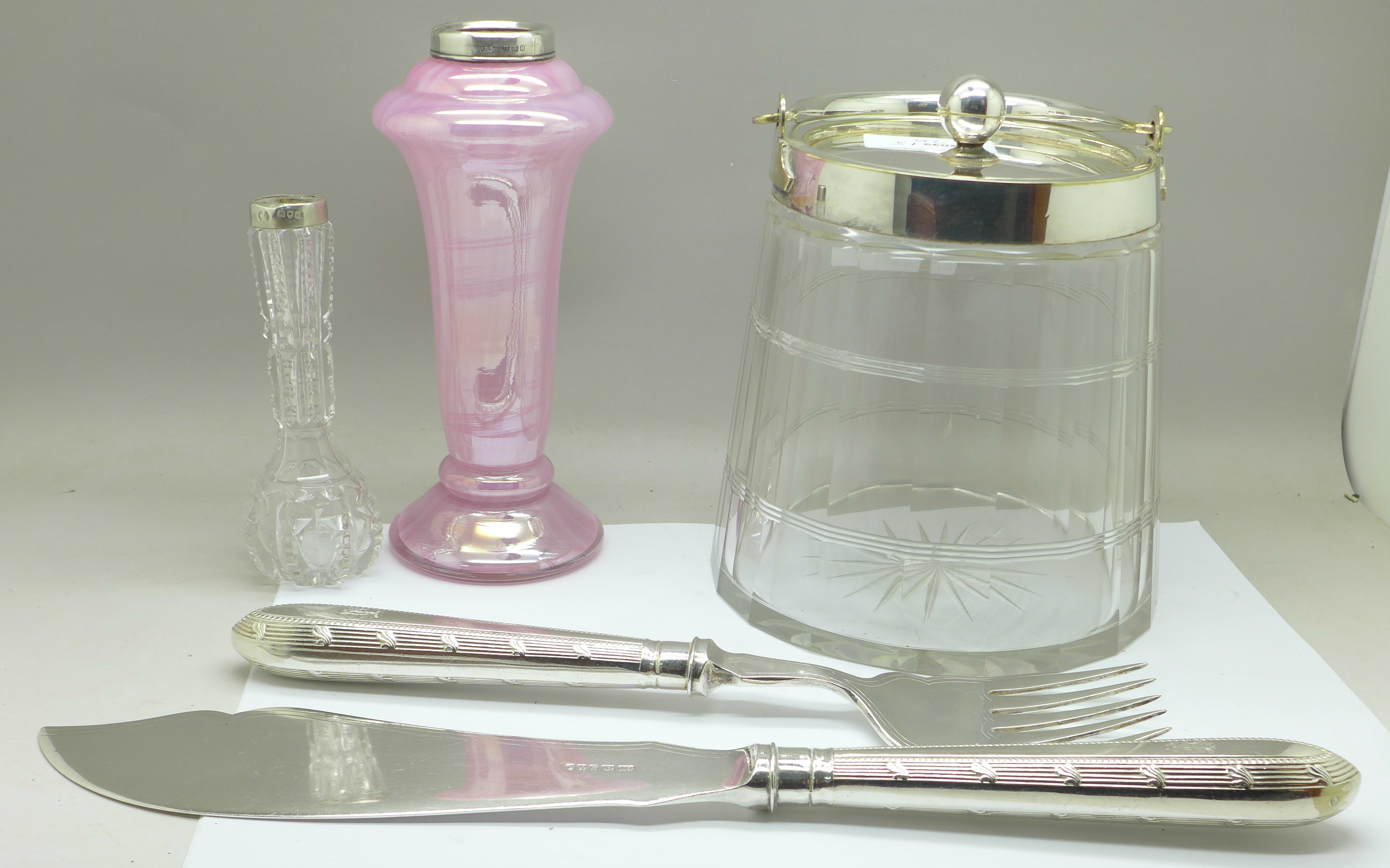 A glass biscuit barrel with plated top, two silver rimmed vases and a silver plated serving set