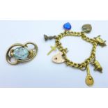 A charm bracelet and a brooch set with a blue stone