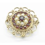 A 9ct gold, garnet and seed pearl cluster brooch, with pendant loop, 8.3g, 3cm