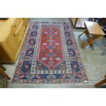 A geometric patterned red ground rug