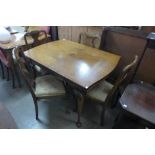 A walnut draw-leaf dining table and four chairs