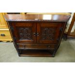 A carved oak credence cupboard