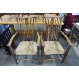 A pair of Arts and Crafts beech rush seated elbow chairs
