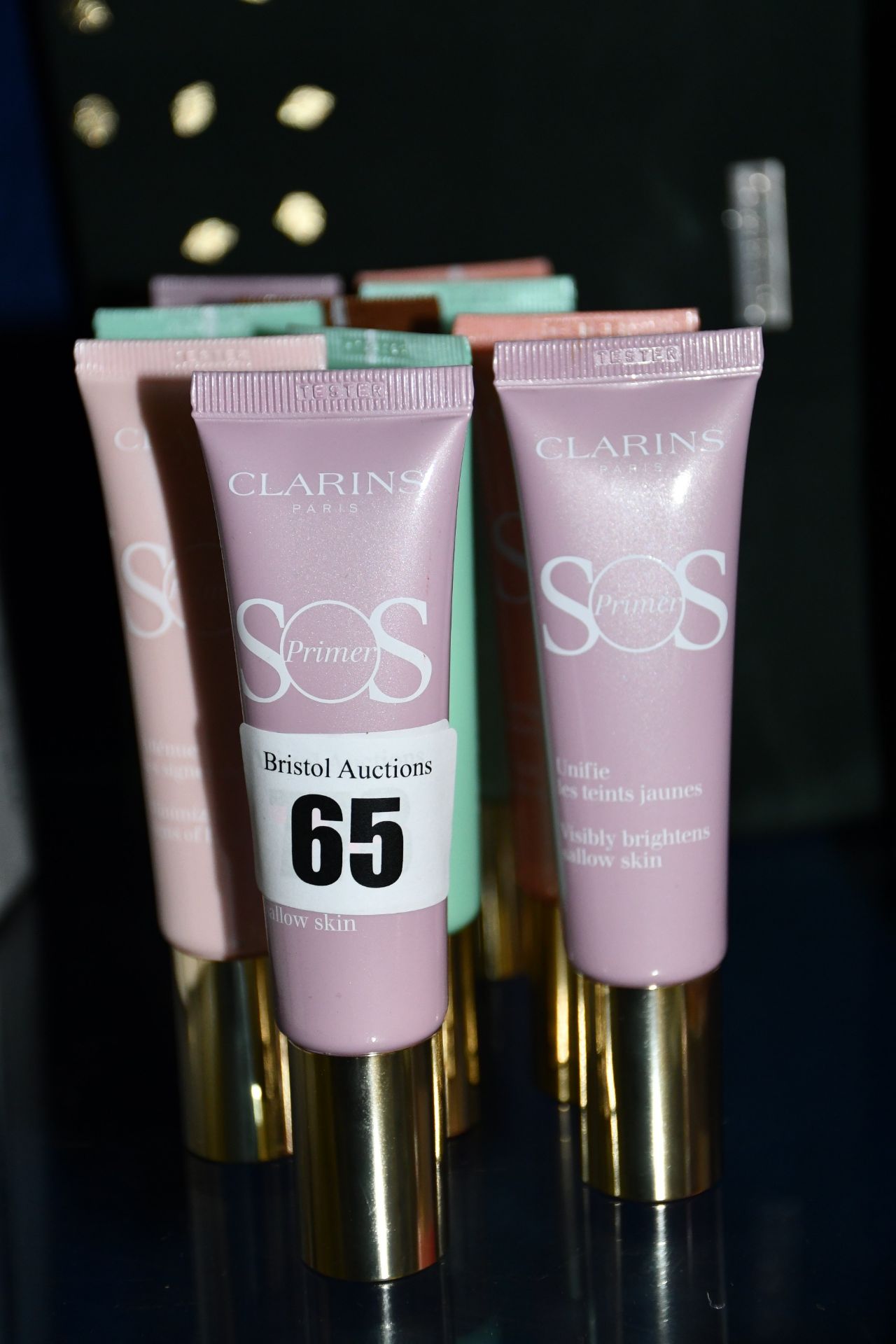 Ten assorted Clarins SOS primers together with a toiletry bag.