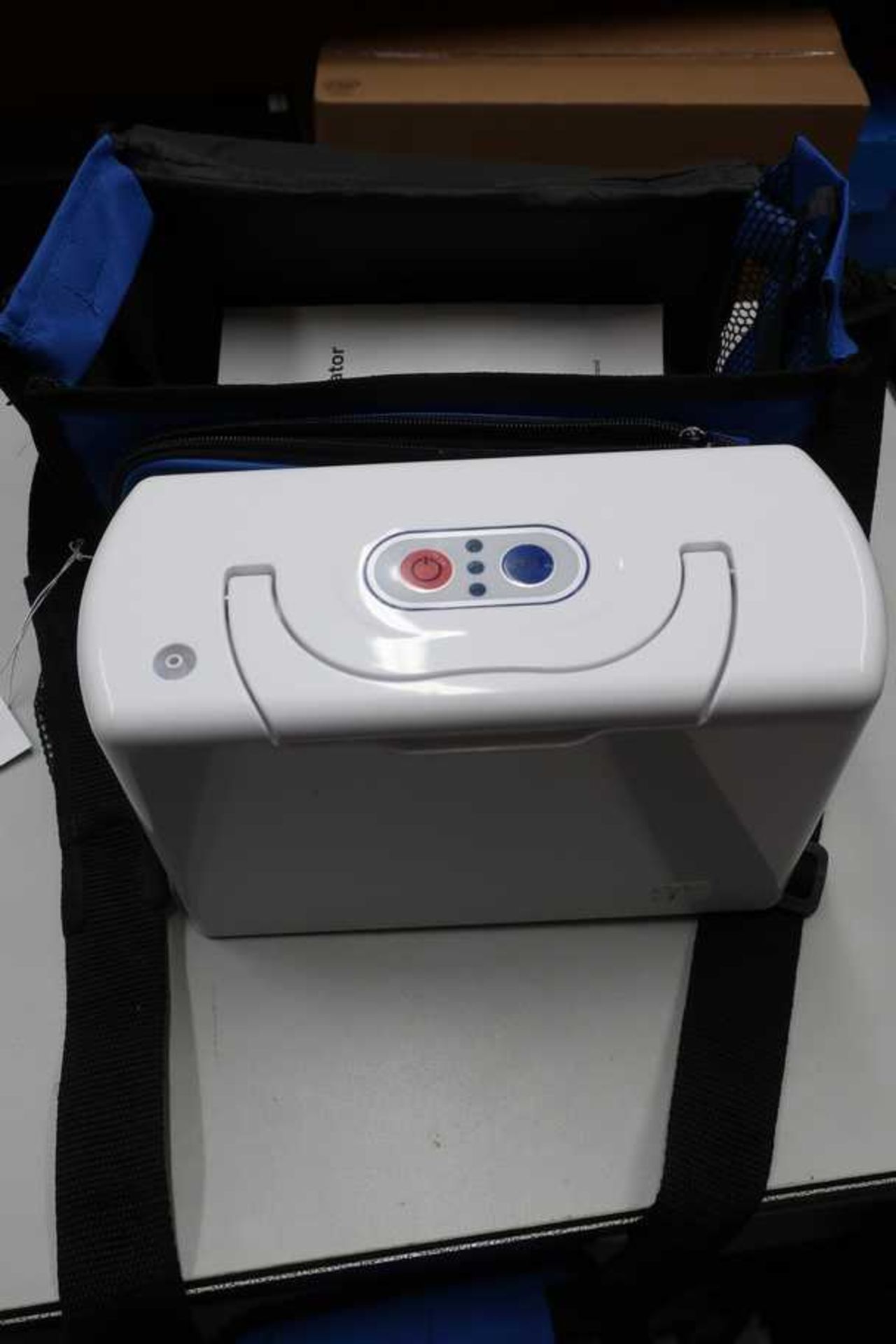 A pre-owned TP-B1 Portable Oxygen Concentrator with power supply and carry bag.
