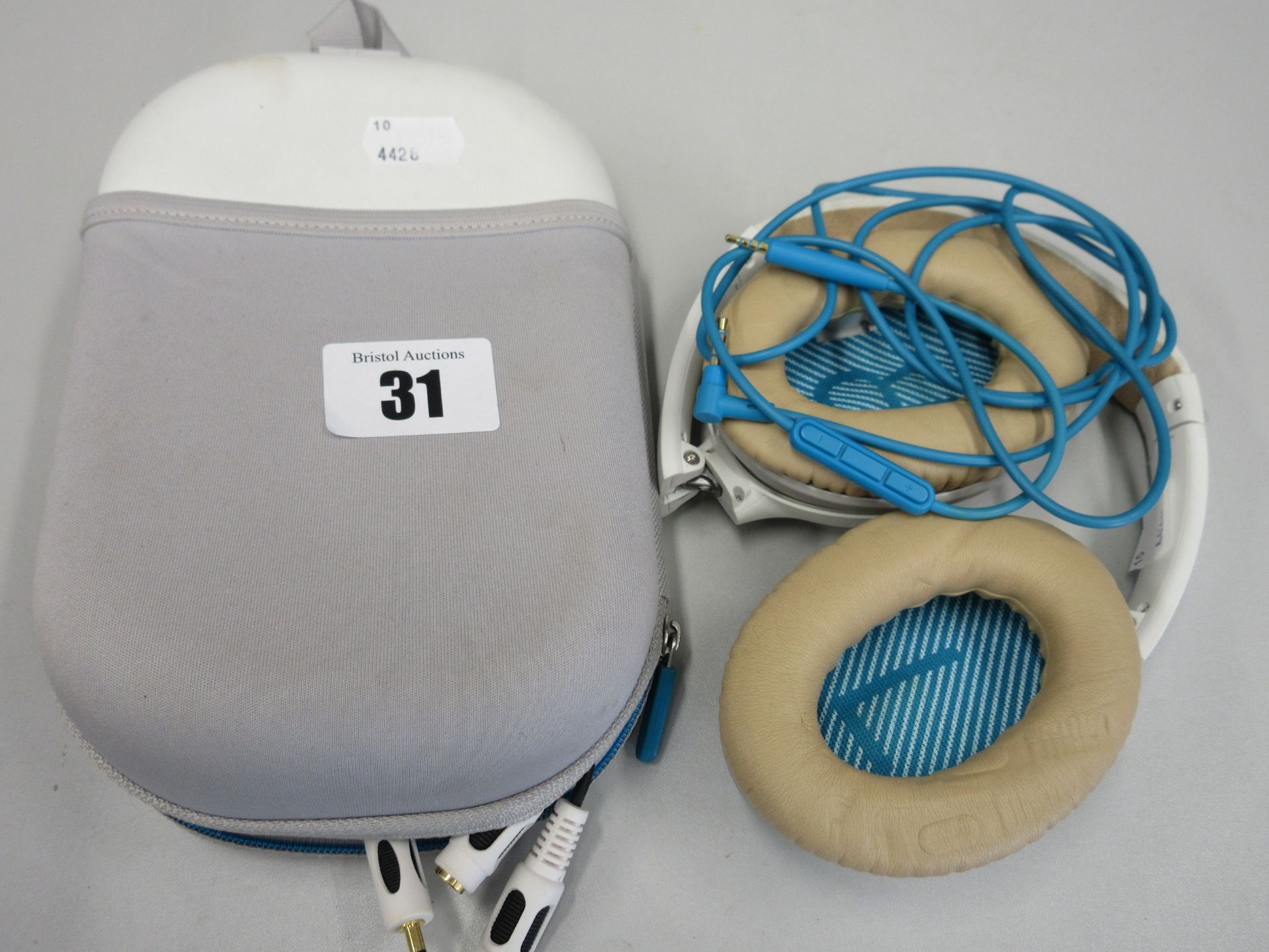 A pair of pre-owned Bose QuietComfort 25 Noise Cancelling Headphones in White with storage case.