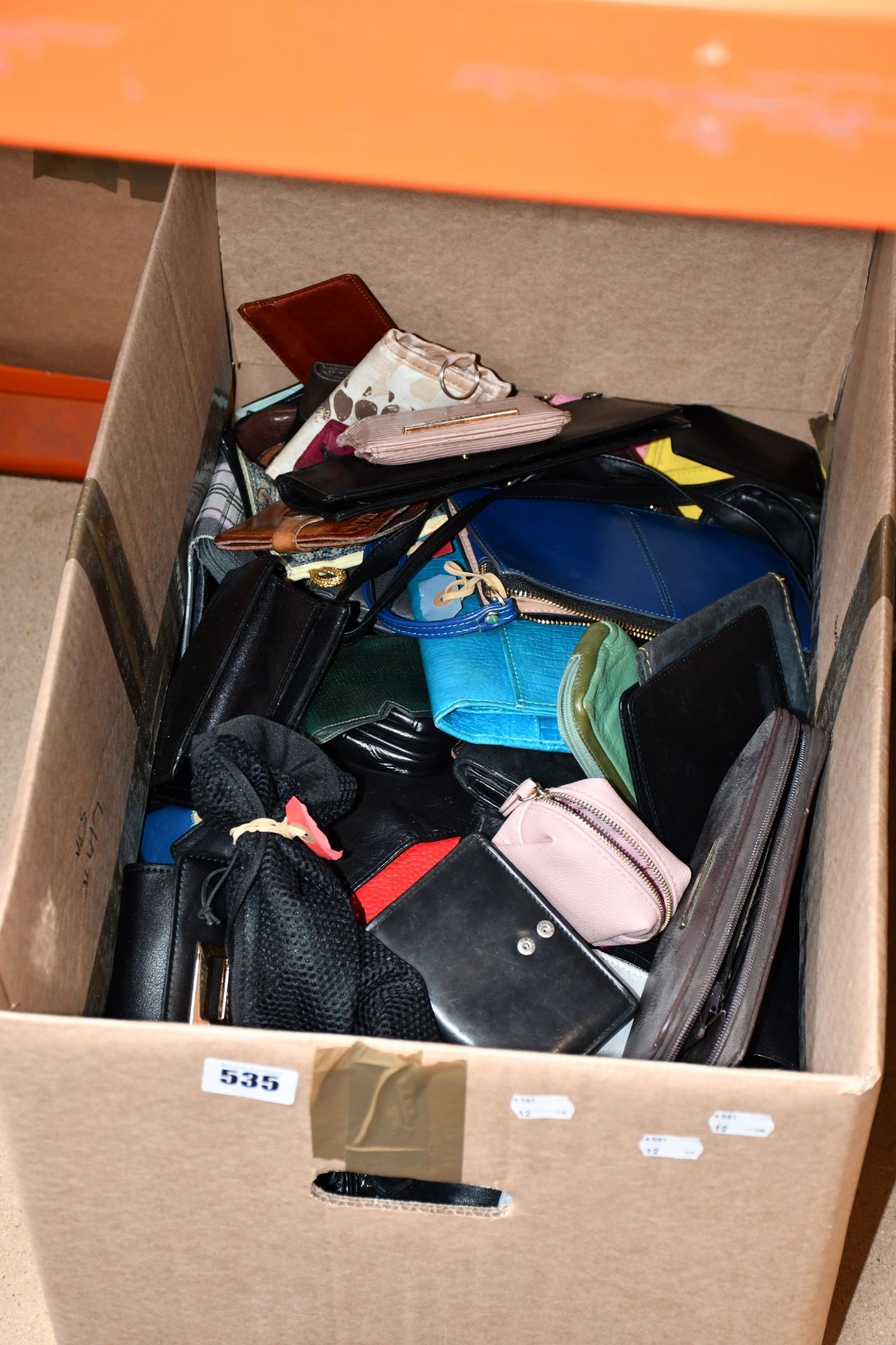 A box of assorted wallets/purses and related items.
