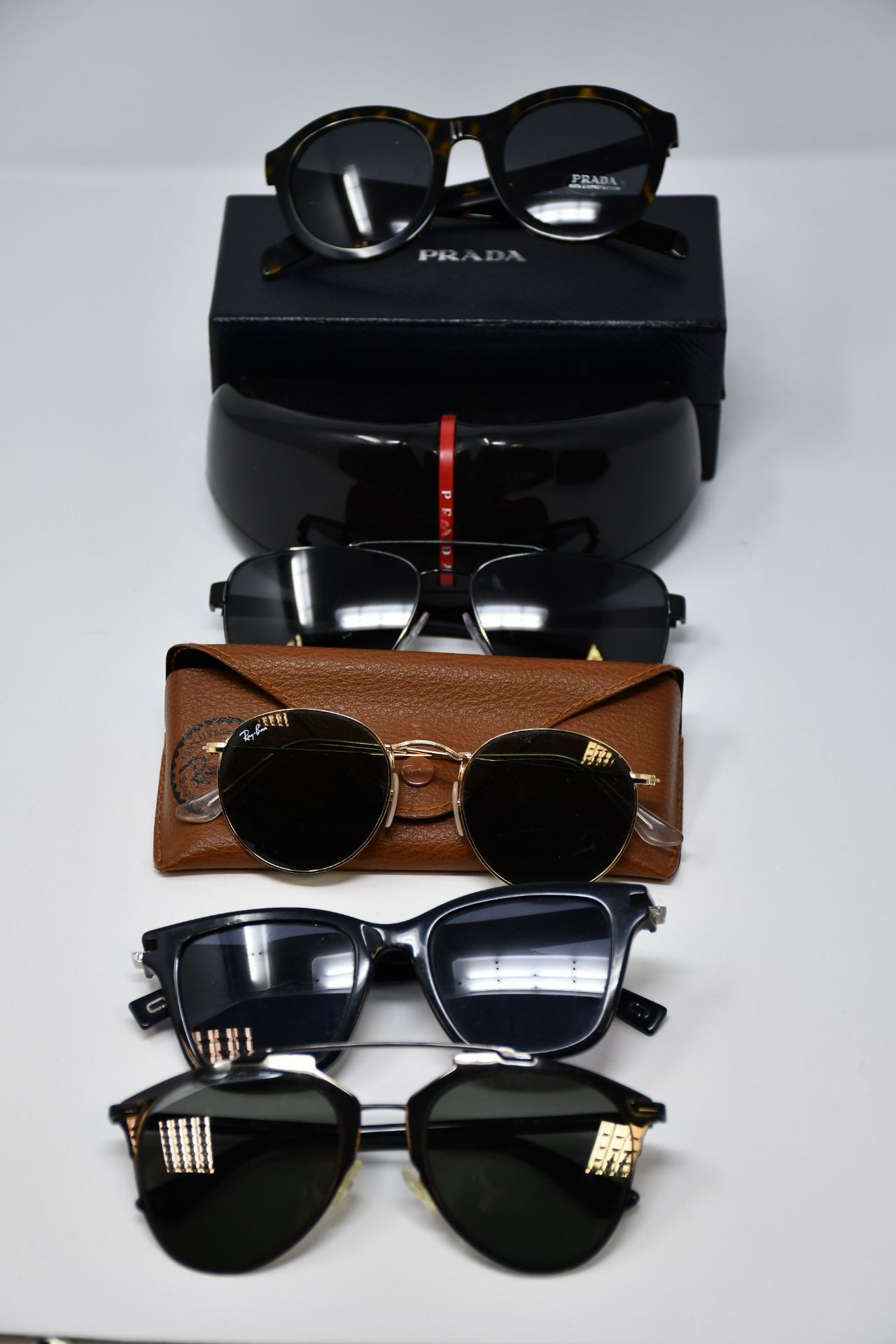 Five pairs of pre-owned branded sunglasses.