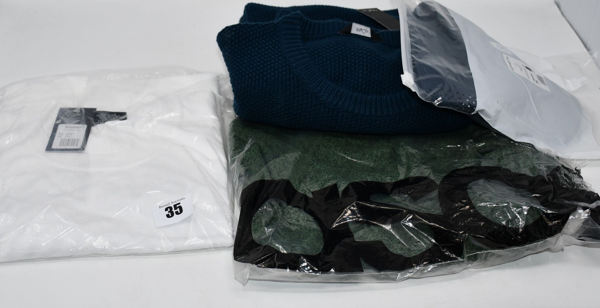 One as new Stussy City Spiral tee size S. One as new Asos Design t-shirt with roll sleeve in green