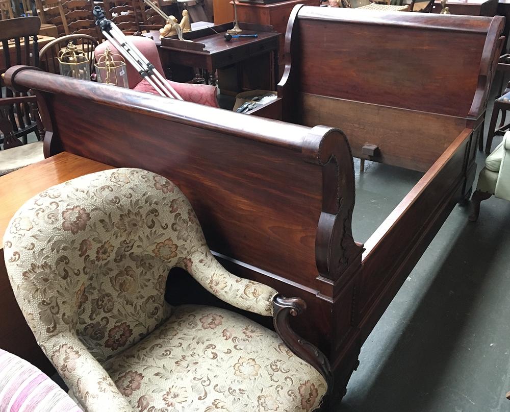 A 19th century mahogany French sleigh bed, the front with carved floral decoration and bead