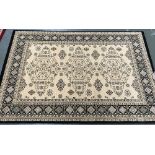 A cream ground rug with black border, 135x200cm