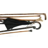 A number of walking canes, one with horn handle, a vintage parasol, a riding crop with the top