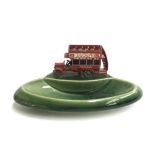 A green ceramic Wade 'Yesteryears' pin dish surmounted by a die cast Matchbox double decker 'Dewar'