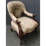 A Victorian open armchair, with scrolling carved supports, serpentine front on casters