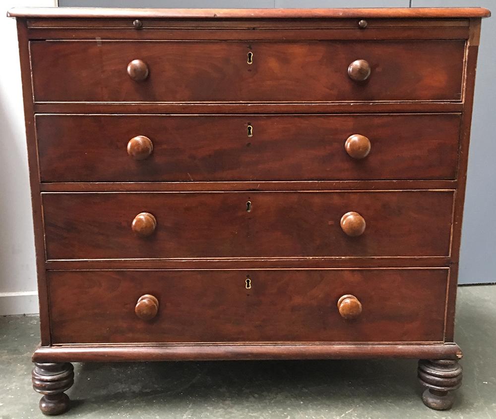 A Georgian and later mahogany chest of four graduating drawers with brushing slide, cross banded top