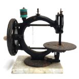 A 19th century sewing machine on marble base with ceramic handle