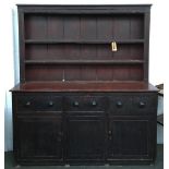 A 19th century stained pine country kitchen dresser, with plate racks, cup hooks, three drawers over