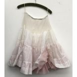 Two underskirts with pink a blue net underlining; a small silk bolero jacket; together with a
