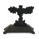An antique fire iron rest with oak tree and acorn design