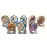 A collection of eight 19th century latticinio marbles (af), all with core swirls, includes