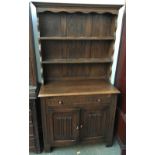 A cottage style kitchen dresser, the single drawer over linenfold carved cupboard doors, 90cmW