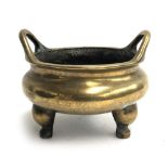 A heavy Chinese brass two handled censer, on three legs, character marks to base surrounded by
