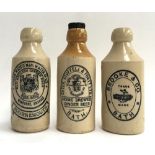 Three stoneware ginger beer bottles: 'Old English Ginger Beer, Wimborne, Swanage, Bournemouth'; '