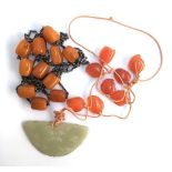 Two necklaces, one with orange hard stone beads, the other set with jade and amber