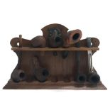 A pipe rack together with a number of pipes, one marked 'Real cherry made in Australia', one