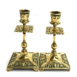A pair of 19th century brass candlesticks, square base with foliate decoration, 16cmH