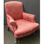 A small armchair, with outward scrolling arms on turned legs and ceramic casters