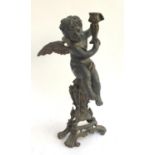 A cast metal winged cherub candle holder, 48.5cmH