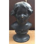 A black painted plaster cast bust of a boy, on circular plinth, 31.5cmH