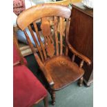 A low splat back Windsor chair, the swept arms on turned supports, raised on turned legs joined by