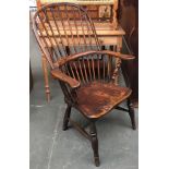 A large 19th century Windsor chair, with carved collar, the arms with turned front supports, above a