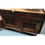 A large oak sideboard, two cushion drawers above two heavily carved cupboard doors, on bracket feet,