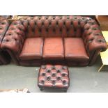An oxblood chesterfield button back three seater sofa, approximately 195cmW; together with a