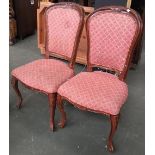 A pair of upholstered occasional chairs, carved top rail on carved cabriole legs