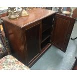 An early 19th century mahogany cupboard, the two fielded panel doors opening to reveal two