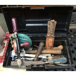 A black plastic toolbox containing a quantity of hand tools