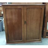 An Edwardian mahogany cupboard of two doors opening to reveal hanging rail and nine slide drawers,