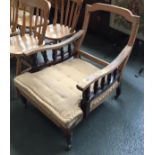 A low 19th century open armchair, in need of complete restoration