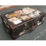 A vintage canvas suitcase, with numerous travel stickers, 69cmW