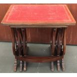 A nest of three tables, with tooled red leather inset tops, on lyre supports with ormolu mounts, the