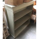 A green painted bookcase of two adjustable shelves, moulded top, stop-fluted canted corners, on