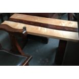 An unusual coffee table, the maple top set with central strips of resin and contrasting wood, on