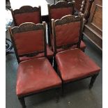 A set of four carved leather upholstered dining chairs on turned legs