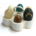 A ceramic egg holder with six polished stone eggs