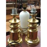 A pair of gilt metal table lamps, 32cmH, together with one other
