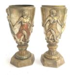 A pair of cast metal vases, surrounded by figures, 29cmH